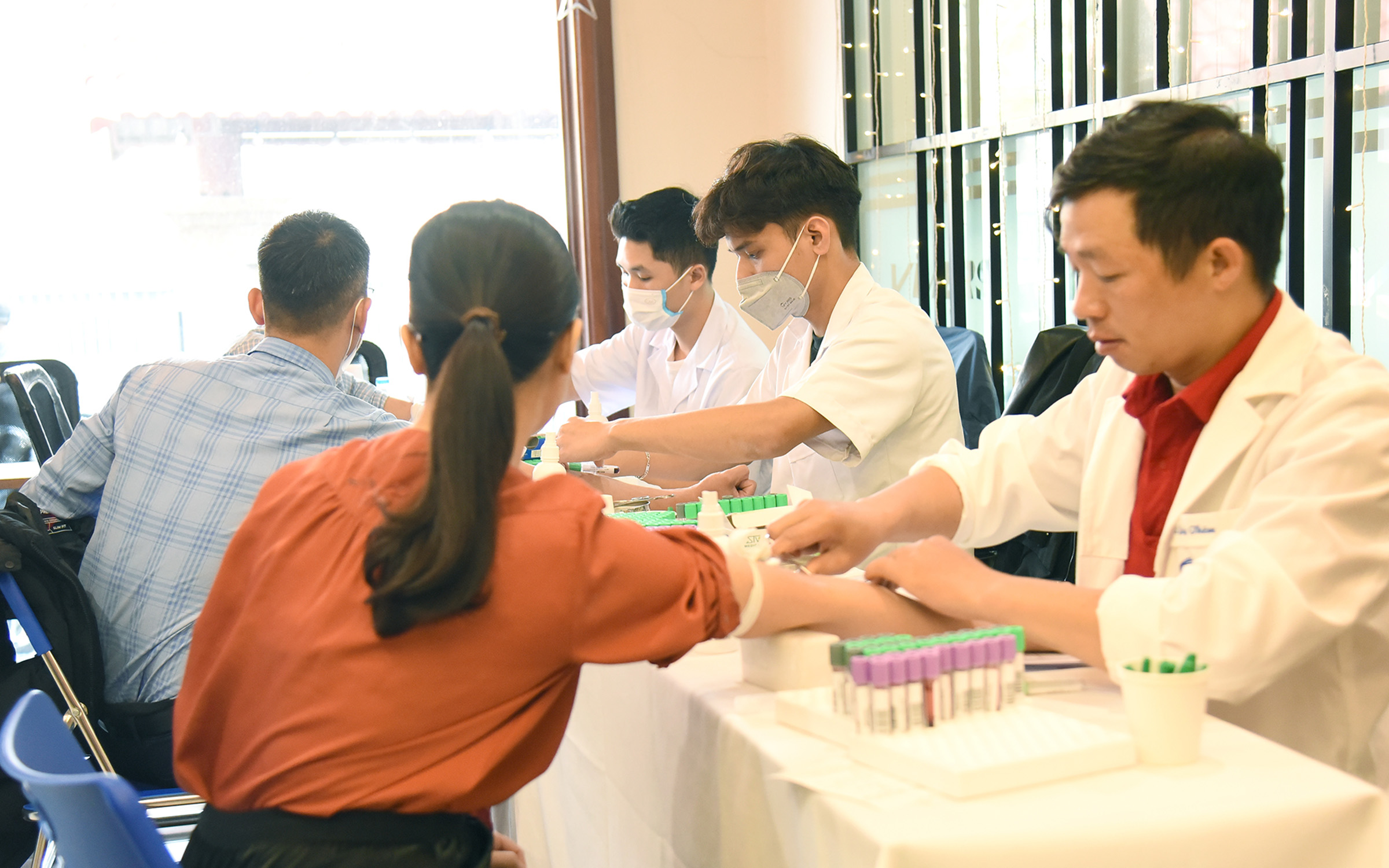 Các bác sỹ Đại học Y Hà Nội đang thực hiện lấy máu xét nghiệm tại văn phòng VIMID